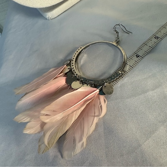 Large silvertone hoop earrings with light pink feathers - Picture 3 of 5
